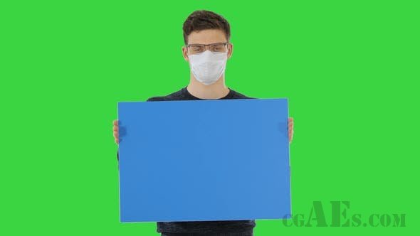 医用口罩的年轻人在绿色屏幕展示标语牌-VIDEOHIVE – YOUNG MAN IN MEDICAL MASK SHOWING AND DISPLAYING PLACARD ON A GREEN SCREEN CHROMA KEY 26313180